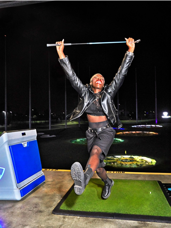 photo of person holding golfclub at topgolf